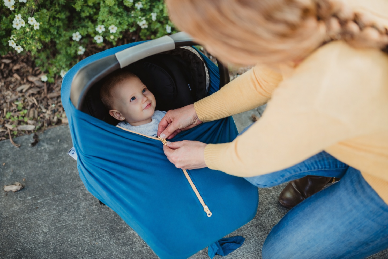 newborn baby in carrier cover with mom