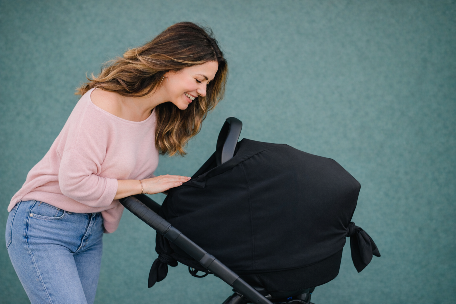 modern mom pushing baby stroller with cover