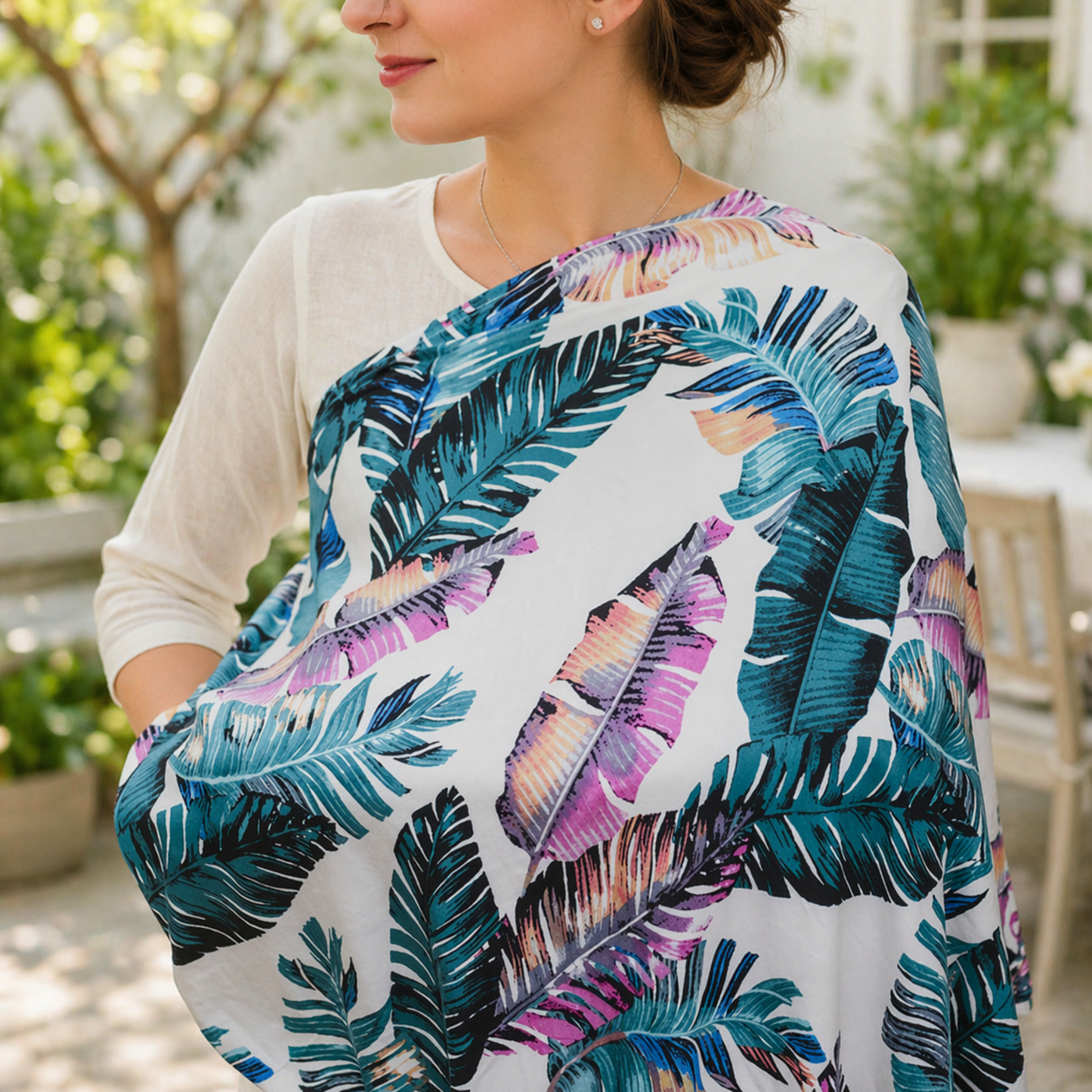 Mom wearing a tropical leaf patterned nursing cover for baby