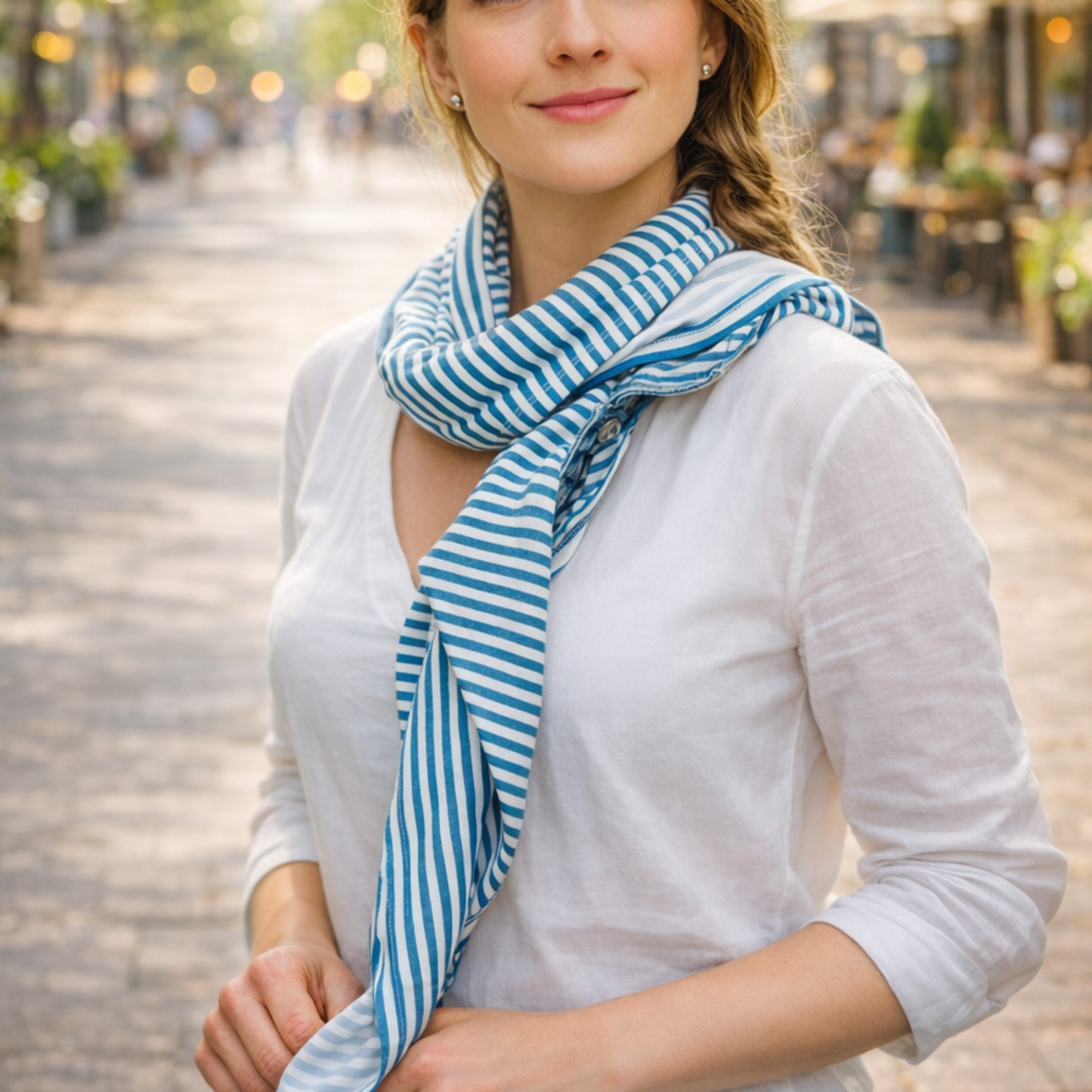 Woman wearing a blue and white striped scarf in an urban setting