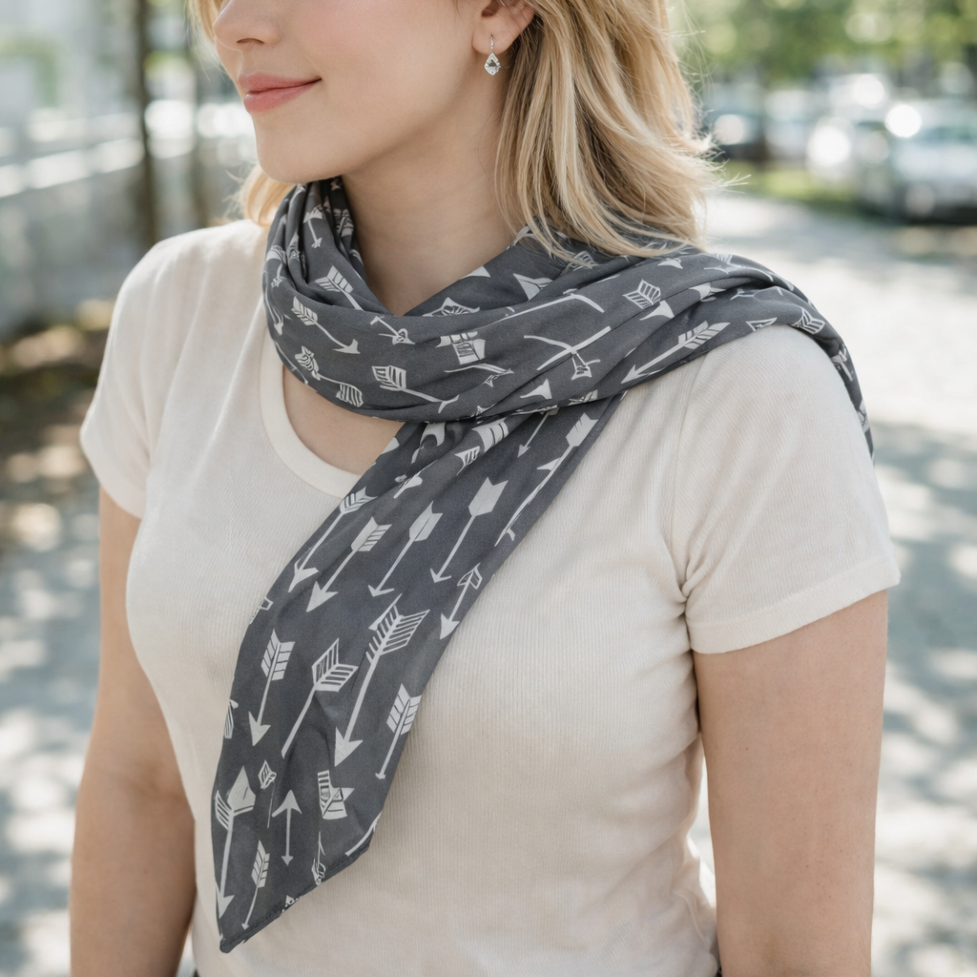 Woman wearing a gray scarf with arrow pattern outdoors